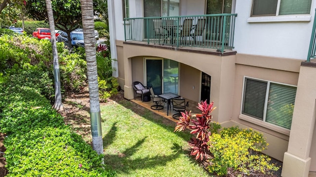 exterior space with a balcony, a yard, and a patio area