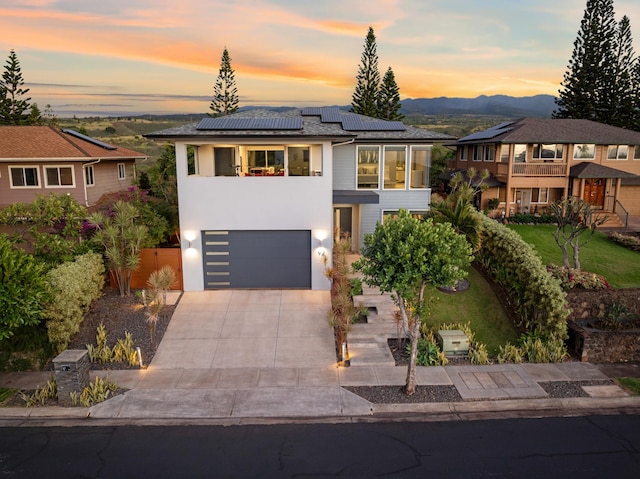 92 Kahana Ridge Dr, Lahaina, HI 96761 - contemporary home featuring a garage, driveway, roof mounted solar panels, a mountain view, and stucco siding