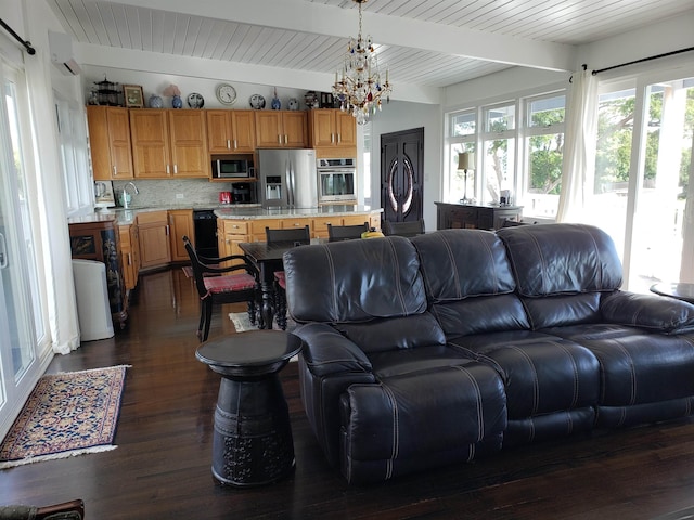 215 Aahi Pl, Kaunakakai, HI 96748 - living area featuring a chandelier, beamed ceiling, dark wood-type flooring, washer / clothes dryer, and a wall mounted air conditioner