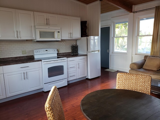 215 Aahi Pl, Kaunakakai, HI 96748 - kitchen with white appliances, dark wood-type flooring, dark countertops, backsplash, and white cabinetry