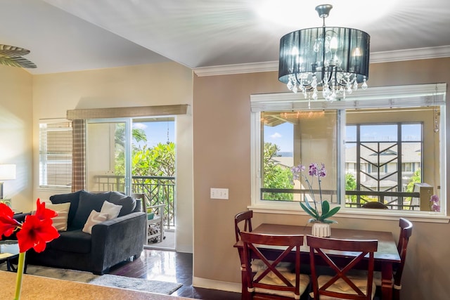 dining space featuring ornamental molding, plenty of natural light, wood-type flooring, and a notable chandelier