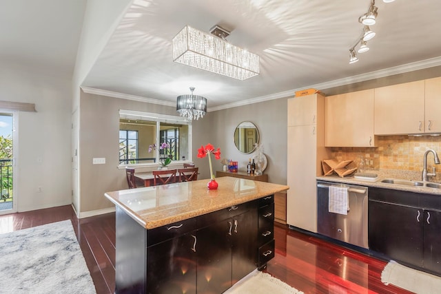 kitchen featuring cream cabinets, sink, a center island, stainless steel dishwasher, and light stone countertops