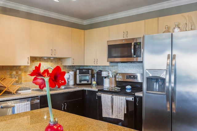 kitchen featuring ornamental molding, appliances with stainless steel finishes, cream cabinetry, and backsplash