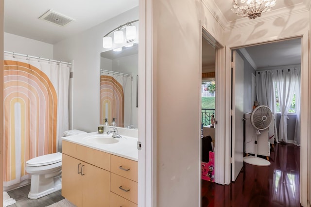 bathroom featuring hardwood / wood-style flooring, vanity, a notable chandelier, ornamental molding, and toilet