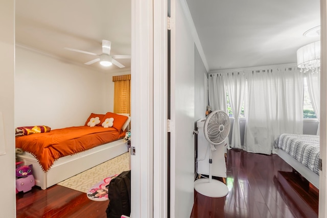 bedroom with wood-type flooring, ornamental molding, and a chandelier