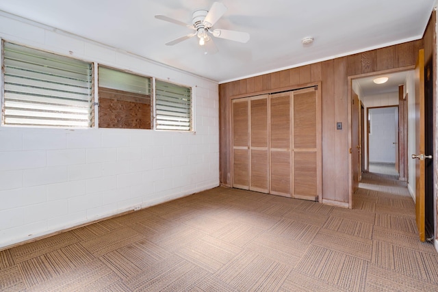 293 Manini Pl, Kihei, HI 96753 - unfurnished bedroom featuring wooden walls, concrete block wall, a ceiling fan, and a closet