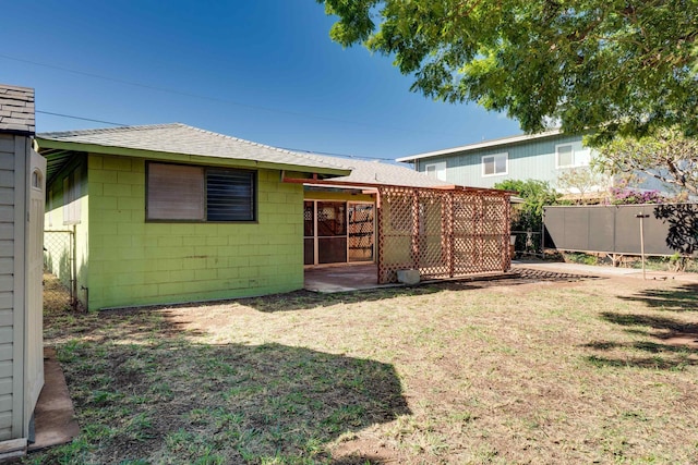 293 Manini Pl, Kihei, HI 96753 - rear view of house featuring a lawn, concrete block siding, fence, and a shingled roof