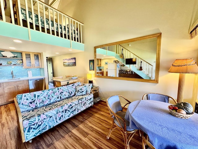 living room featuring hardwood / wood-style flooring, a high ceiling, and wet bar