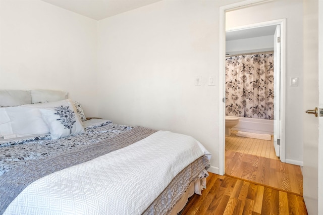 bedroom with wood-type flooring and connected bathroom