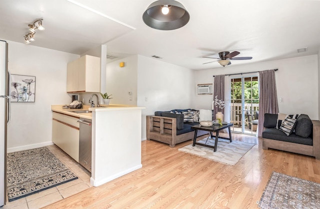 kitchen with kitchen peninsula, ceiling fan, sink, light hardwood / wood-style flooring, and dishwasher