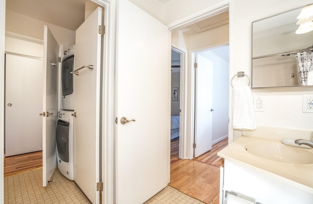 bathroom featuring hardwood / wood-style flooring, vanity, and stacked washer / dryer