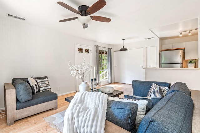 living room with ceiling fan and light hardwood / wood-style flooring