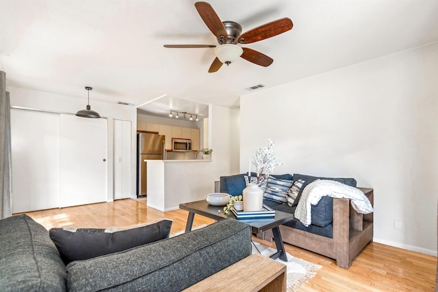 living room featuring light hardwood / wood-style flooring and ceiling fan