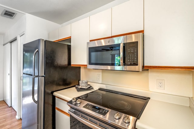 kitchen featuring white cabinetry, stainless steel appliances, and light wood-type flooring