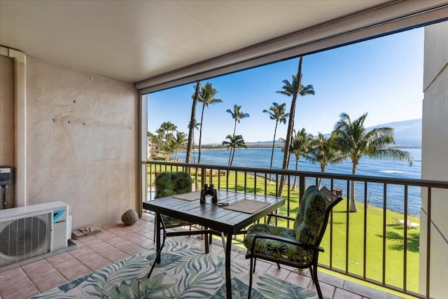 sunroom / solarium featuring ac unit and a water view