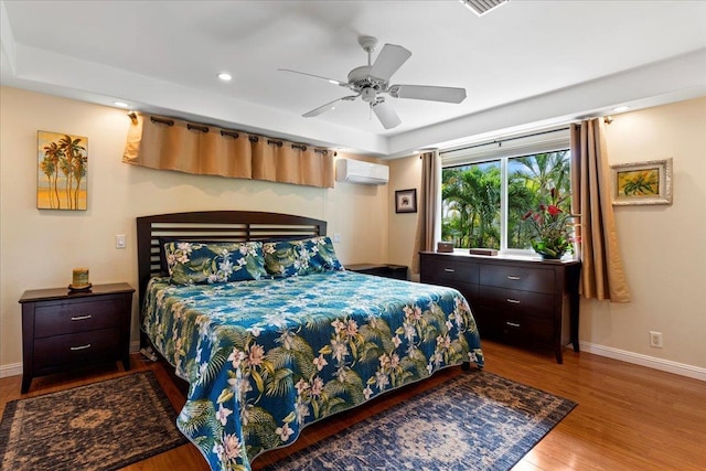 bedroom featuring light wood-type flooring, a wall mounted AC, and ceiling fan