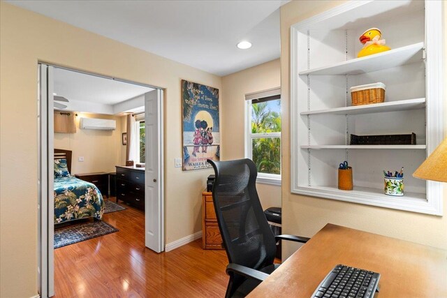 office area featuring a wall mounted AC and hardwood / wood-style flooring