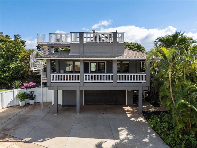 raised beach house featuring a balcony and a garage