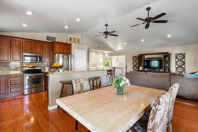 dining area featuring lofted ceiling, ceiling fan, and dark wood-type flooring