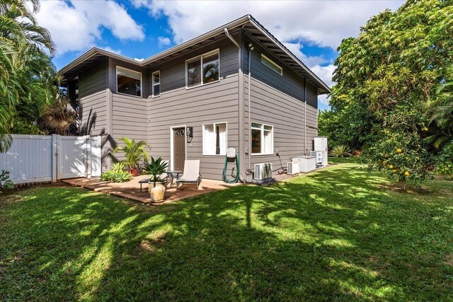 back of house featuring central AC unit, a yard, and a patio area