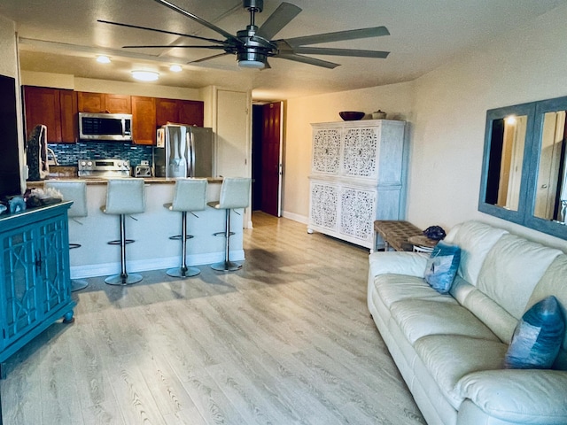 living area with a ceiling fan and light wood finished floors