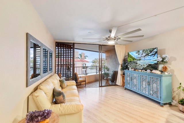 living area with a ceiling fan and wood finished floors