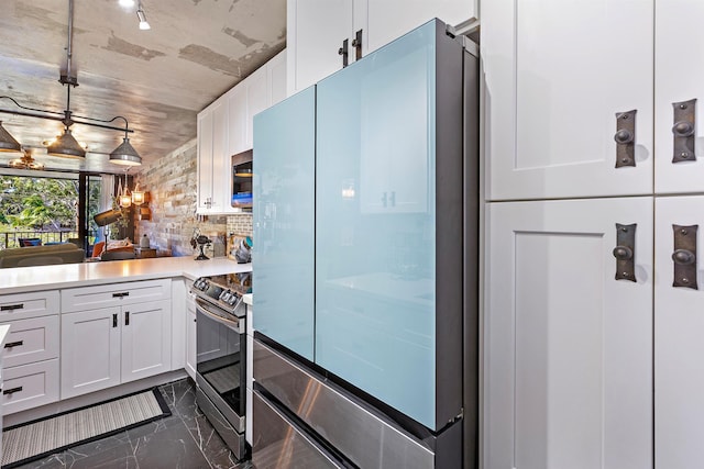 kitchen with light countertops, appliances with stainless steel finishes, white cabinetry, and decorative backsplash