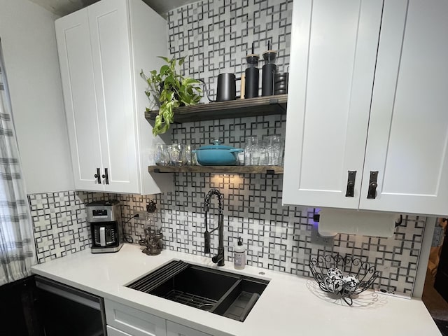 kitchen with white cabinets, light countertops, a sink, and open shelves