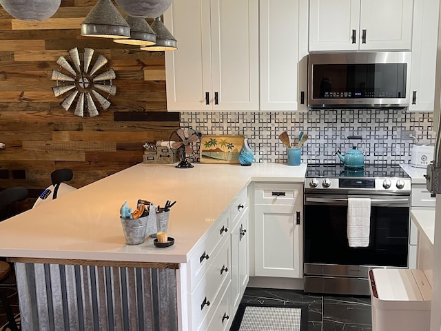 kitchen featuring stainless steel appliances, backsplash, light countertops, and white cabinets