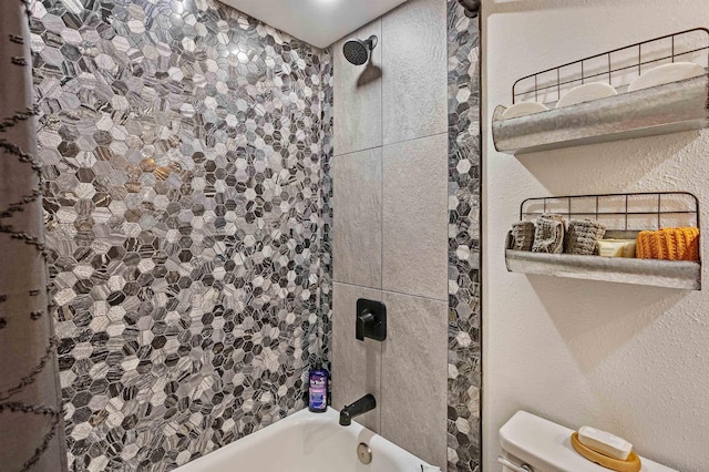 full bathroom featuring a textured wall, shower / bathing tub combination, and toilet