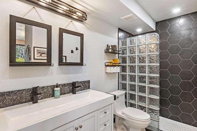 full bathroom with visible vents, vanity, toilet, and a walk in shower