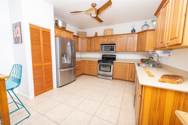 kitchen featuring appliances with stainless steel finishes, ceiling fan, sink, and light tile flooring