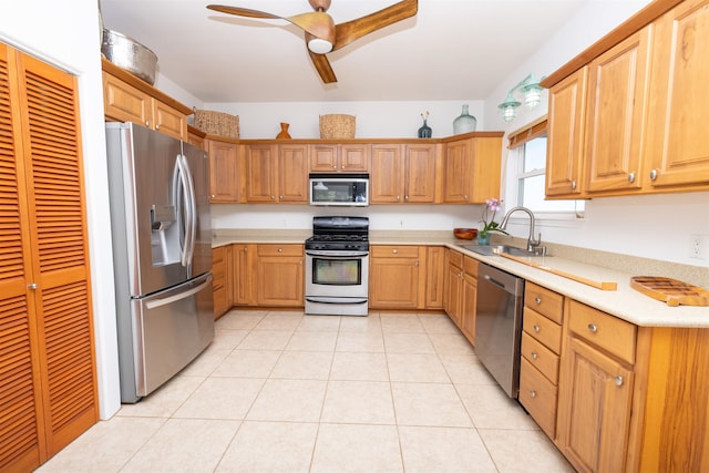 kitchen with appliances with stainless steel finishes, ceiling fan, light tile flooring, and sink