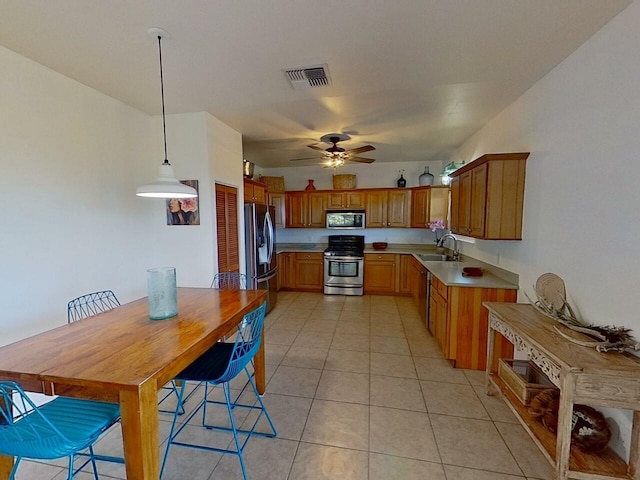 kitchen with light tile floors, stainless steel appliances, sink, ceiling fan, and pendant lighting