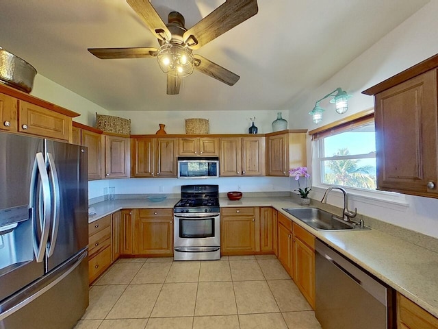 kitchen with ceiling fan, sink, stainless steel appliances, and light tile floors