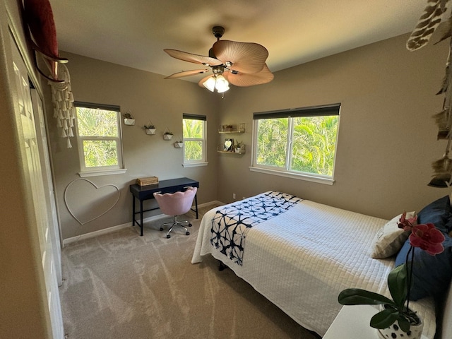 carpeted bedroom with ceiling fan and multiple windows