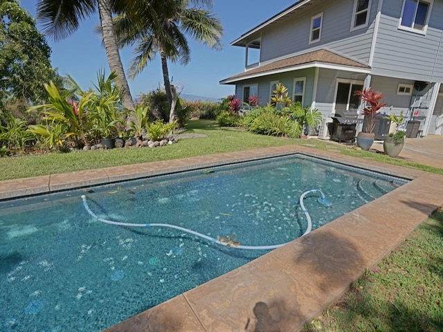 view of swimming pool featuring a lawn