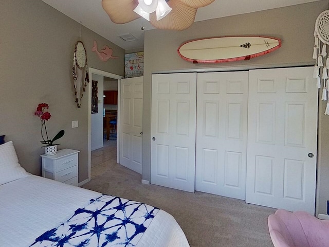 bedroom featuring ceiling fan, a closet, and light carpet