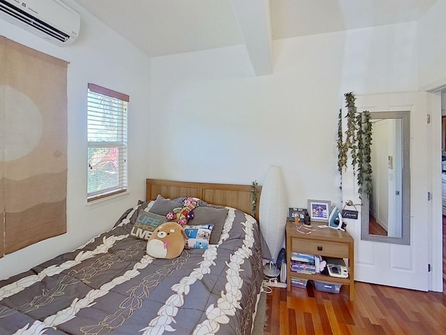 bedroom featuring an AC wall unit and dark hardwood / wood-style floors