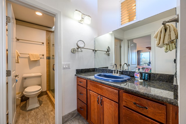 bathroom with toilet, an enclosed shower, and vanity