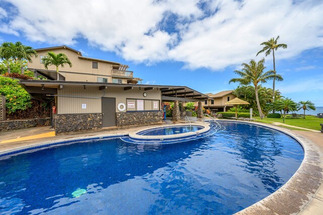 view of swimming pool with a hot tub