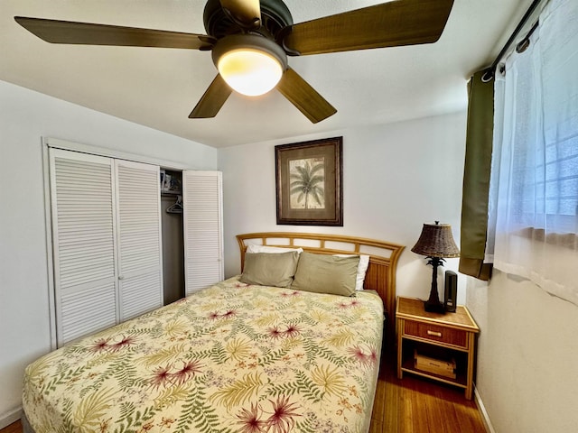 bedroom with wood finished floors, a closet, a ceiling fan, and baseboards