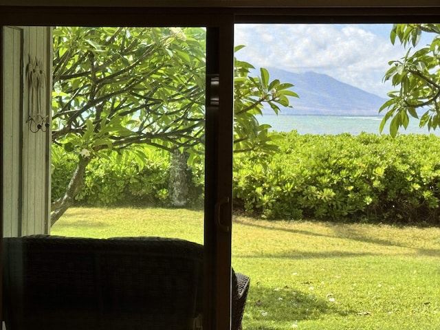view of green lawn featuring a water view