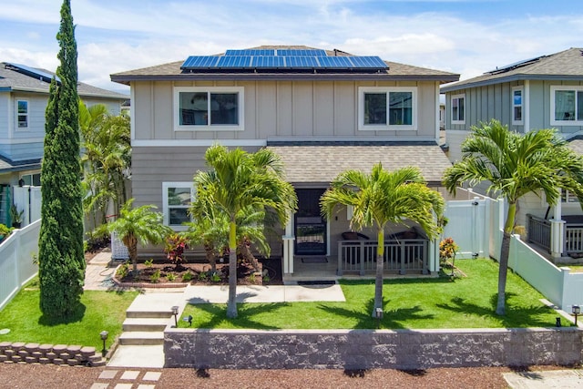 view of front of property featuring solar panels and a front lawn