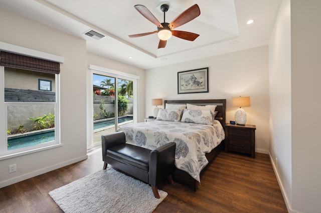 bedroom featuring baseboards, visible vents, access to exterior, dark wood-type flooring, and a raised ceiling