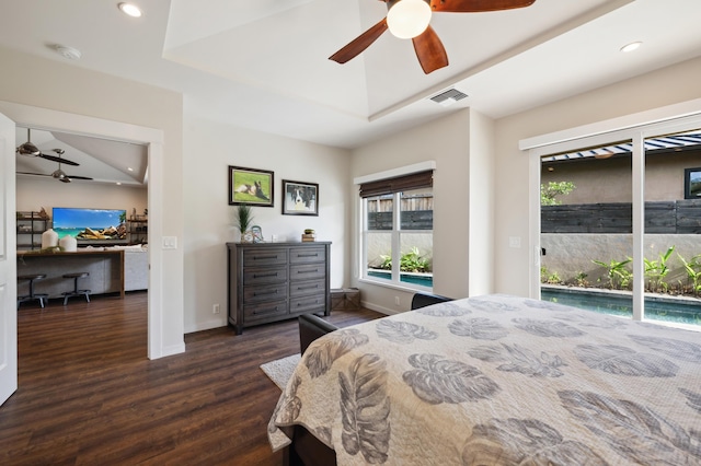 bedroom with visible vents, dark wood-type flooring, a tray ceiling, recessed lighting, and access to outside