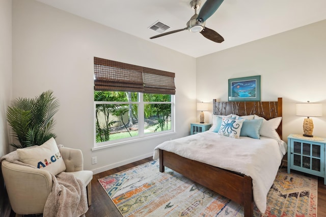 bedroom with ceiling fan, visible vents, baseboards, and wood finished floors