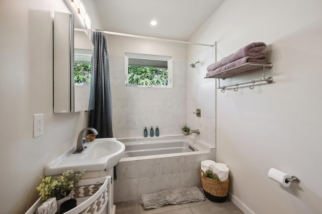 bathroom featuring tile patterned floors, tiled shower / bath combo, and a sink