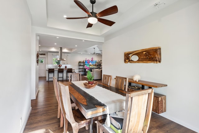 dining room with baseboards, dark wood finished floors, recessed lighting, ceiling fan, and a raised ceiling