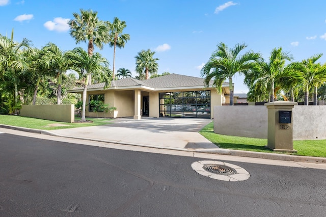 view of front of property with fence, driveway, and stucco siding